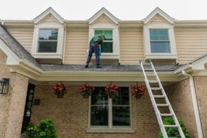 window washer on the ladder cleaning windows