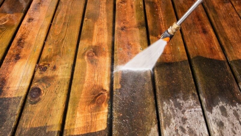 a person cleaning a wood deck