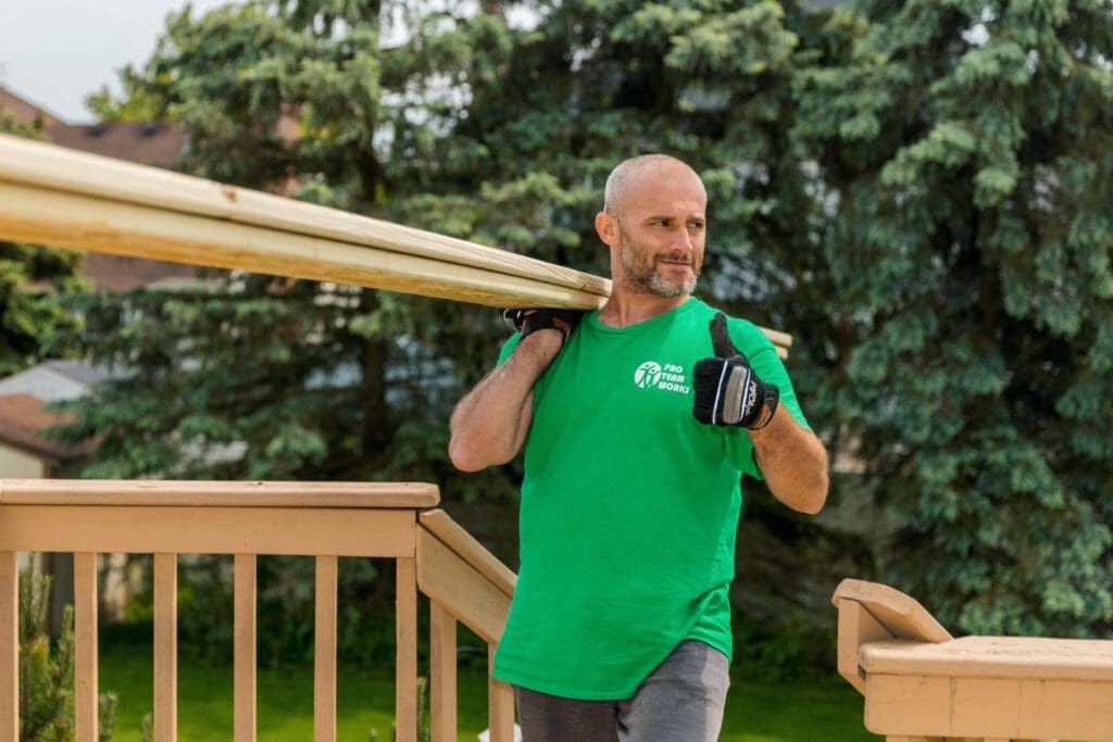 A man carrying timber for deck building.