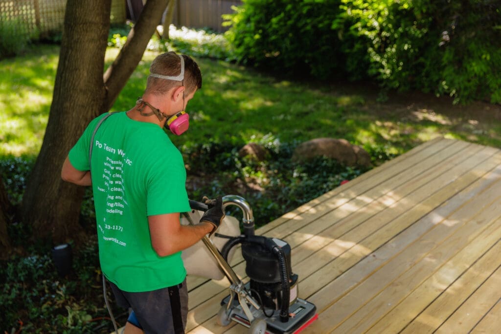 Sanding a deck surface in preparation for staining
