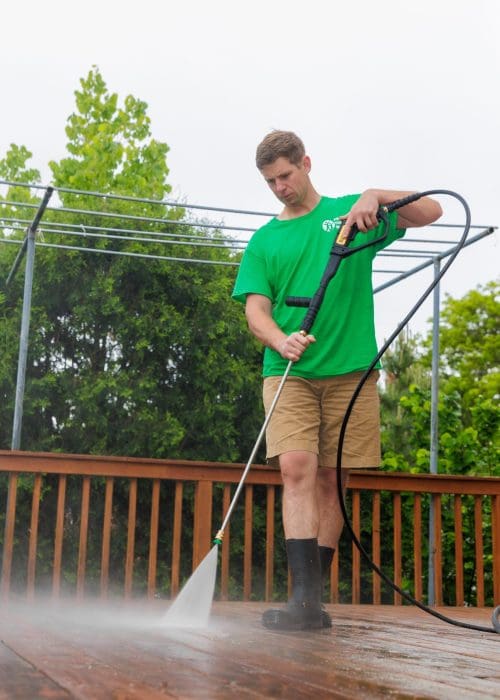 a man power washing a deck